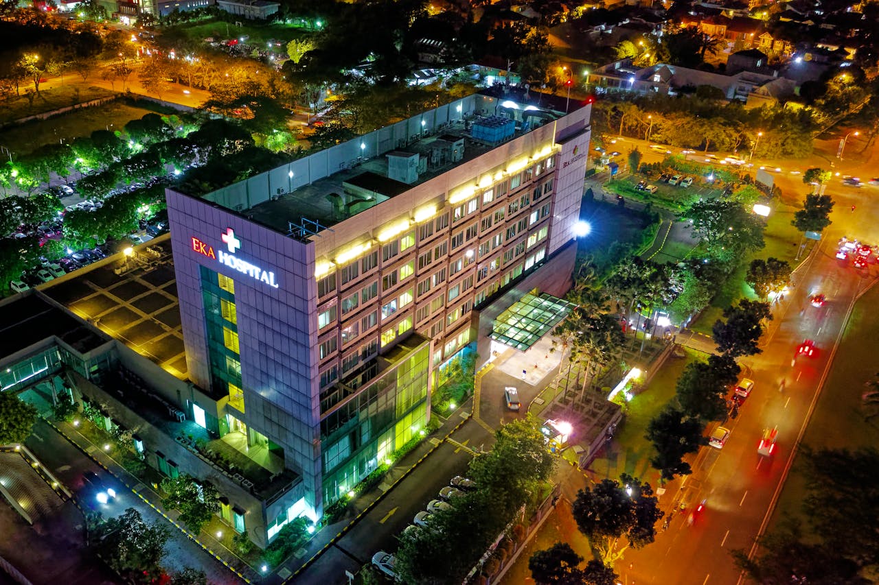 services-02 Stunning aerial view of Eka Hospital in Serpong, Indonesia, illuminated at night, capturing vibrant city lights and architecture.