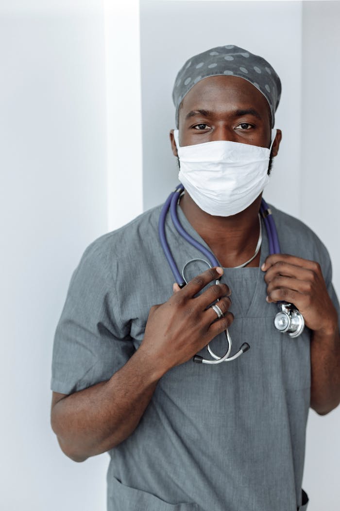 Pierwsze wrażenie: Twój intrygujący tytuł wpisu Portrait of a healthcare worker wearing a face mask and scrubs, demonstrating COVID-19 safety measures.